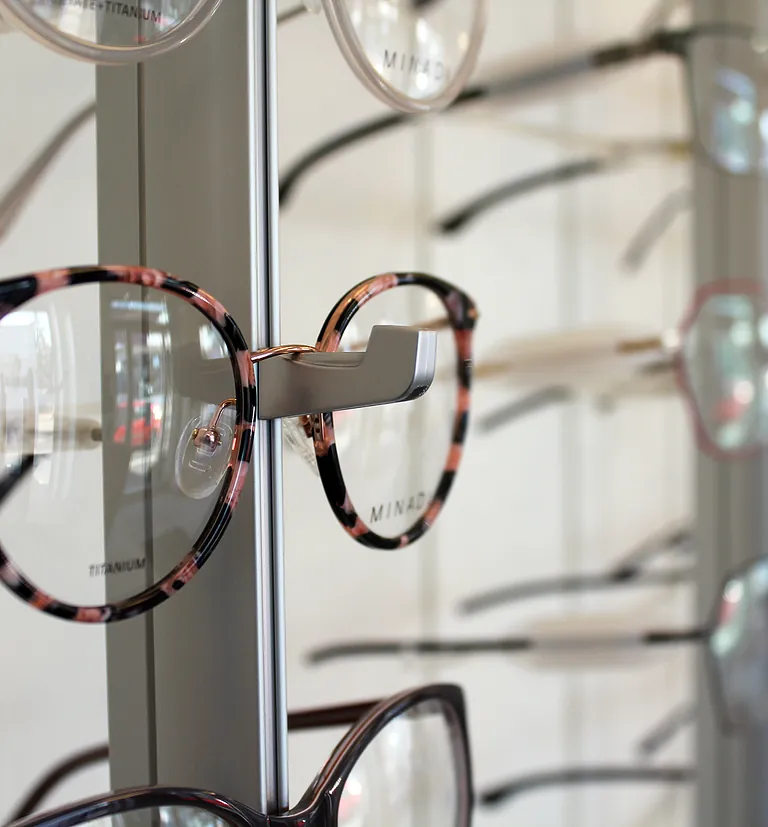 Brille im Fokus fotografiert an einem Brillenregal